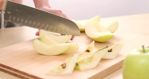 Apfel auf Holzbrett schneiden