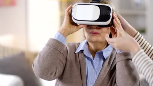 Senior Woman Experiences Virtual Reality Headset at Home