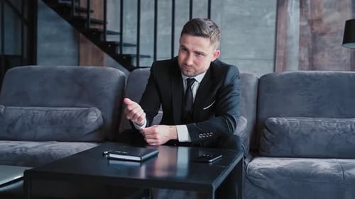 Confident Man in Suit Sitting on Couch
