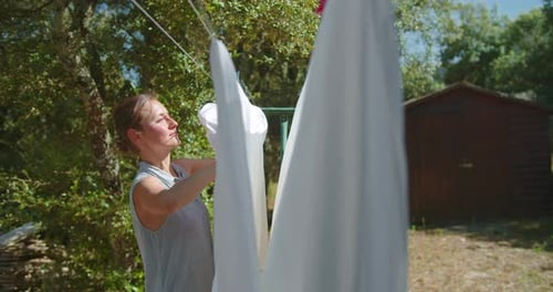 Woman Hanging Laundry on Clothesline Outdoors
