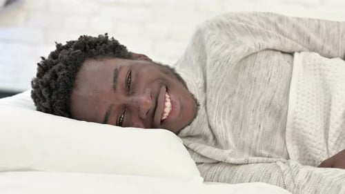 Man Lying in Bed Smiling at Camera