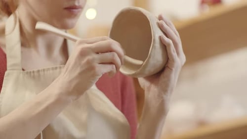 Artist Smoothing Ceramic Bowl in Workshop