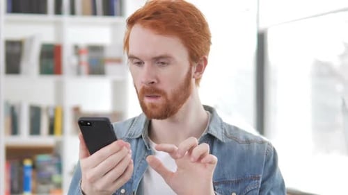 Excited Young Adult Cheering While Looking at Phone