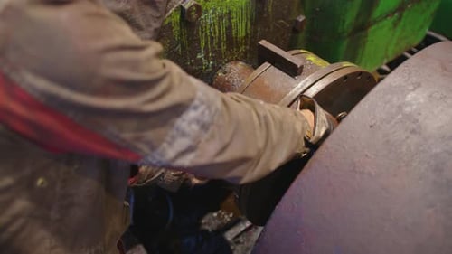 Mechanic Repairing Equipment in an Industrial Setting