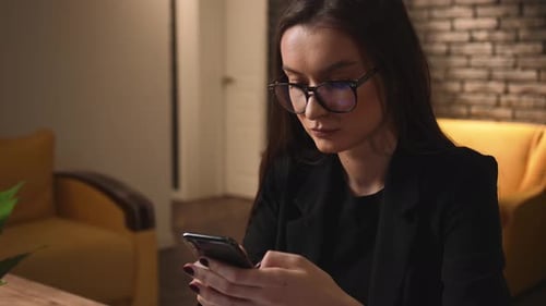 Woman Using Phone in Office Environment