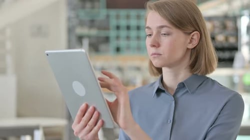 Adult Woman Using Tablet in Workplace Setting