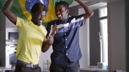 Friends Celebrating Sports Victory with Flag Indoors