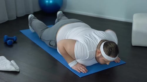 Adult Doing Pushups on Exercise Mat in Home
