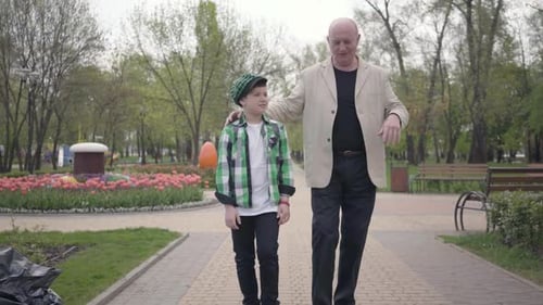 Portrait Cute Grandfather and Adorable Grandson Walking To Camera in the Park