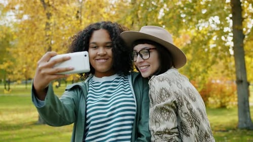 Attraktive junge Frauen machen Selfie im Park und posieren Spaß im Freien