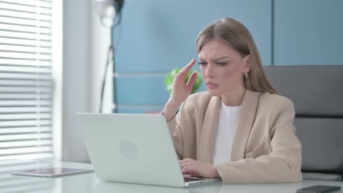 Businesswoman Working at Desk with Laptop in Office