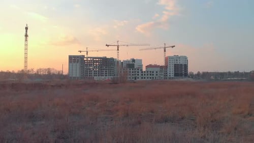 Construction Site at Sunset with Towering Cranes