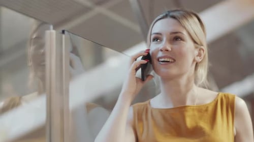 Woman Talking on Her Phone Indoors Smiling