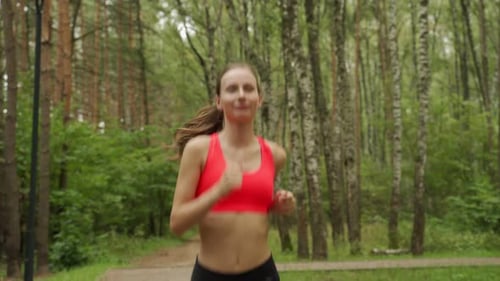 Young Woman Runs Through a Colorful Autumn Forest She is Doing Her Running Workout Outdoor