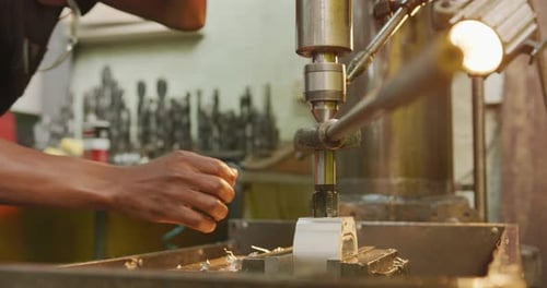 Kaukasischer Mann händet Fabrikarbeiter in einer Fabrik, steht an einer Werkbank und bedient Maschinen