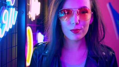 Stylish Woman Posing by Neon Lights at Night