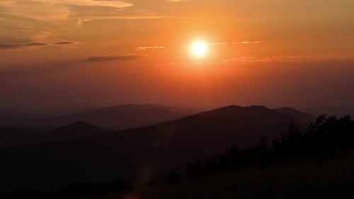 Brilliant Sunrise Over Distant Mountain Silhouette