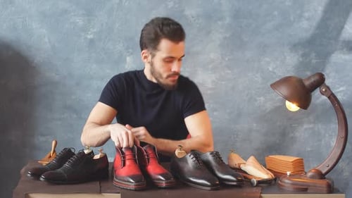 Man Arranging Leather Shoes on Table