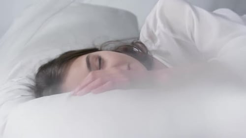Woman Lying in Bed Looking at Camera
