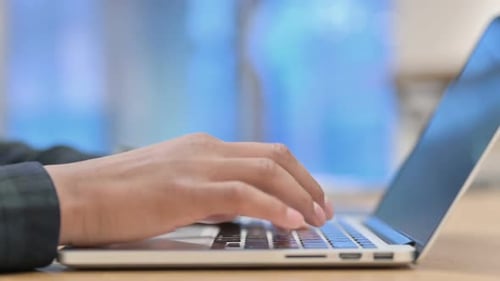 Close Up of African Hands Typing on Laptop