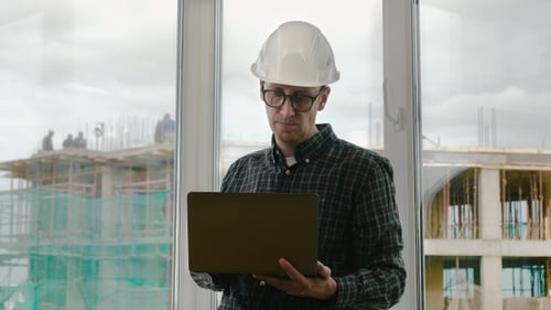 Handsome male engineer is using a notebook for work