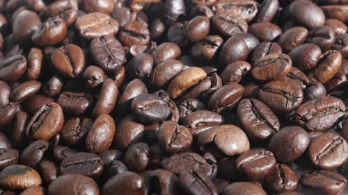Panning over roasted coffee beans close-up 4K footage