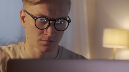 Young Caucasian Freelancer Man Working on Computer at Home at Night
