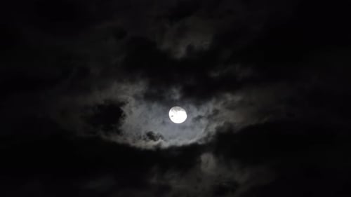 Dramatic Moon Shining Behind Moving Dark Clouds