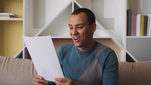 Young Man Smiles After Reading Good News
