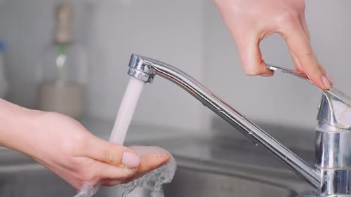 Water Running from Faucet into Sink in Kitchen