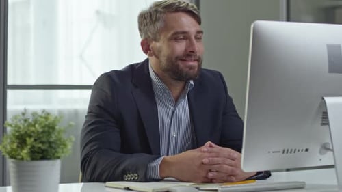 Businessman Attending Video Conference at Desk