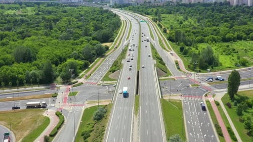 Top view of freay road. Clip. Highway with traffic in forest. Suburban highway with cars and trucks.