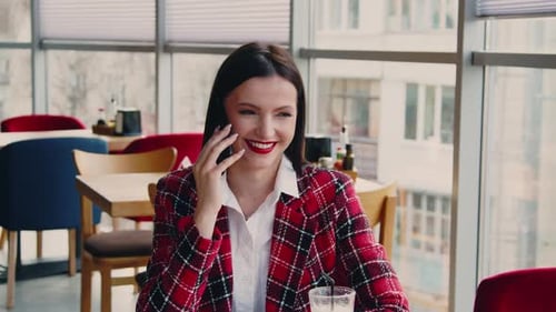 Young Woman Talking on Smartphone Indoors