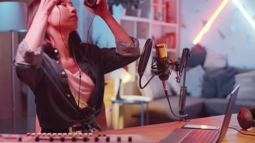 Female Asian Sound Producer Recording Music in Home Studio