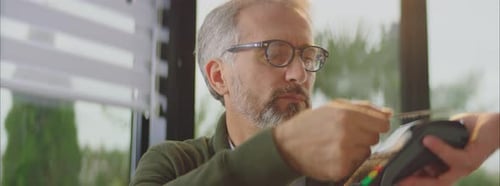 Reifer Mann zahlt Rechnung im Café mit Karte