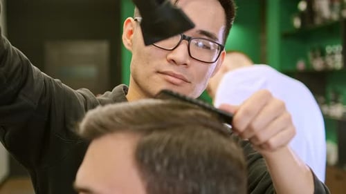 Barber Styling Hair with Dryer and Comb