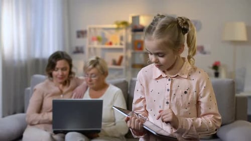Grandchild Playing Tablet Game, Mother and Grandparent Using Laptop, Technology