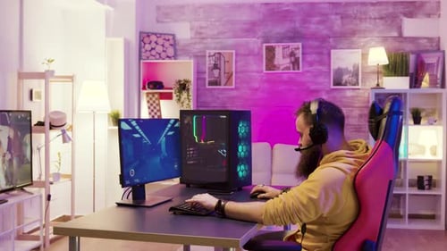Man Playing Computer Game in Neon Lit Room