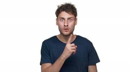 Porträt eines unrasierten kaukasischen Mannes, der mit strengem Blick posiert und bittet, Schweigen zu bewahren und Index zu setzen