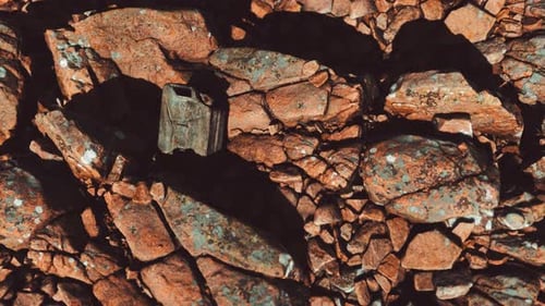 Old Rusty Metal Canister for Gasoline Fuel at Rocks