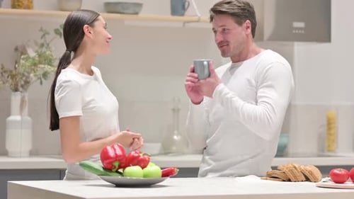 Couple Talking in Kitchen and Drinking from Mug