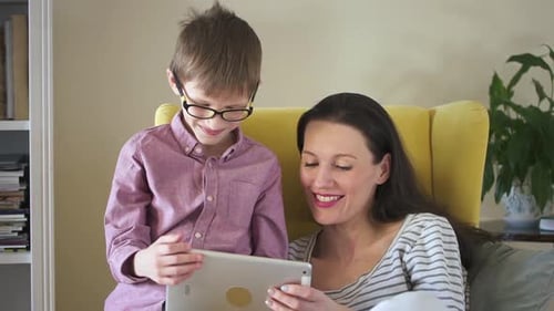 Woman and Child Looking at Tablet Together Indoors