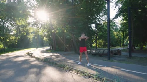 Fit Man Doing Exercises in Sunlit Park