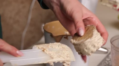 A Woman Makes A Biscuit Cake. Applies Butter Cream To The Workpieces. Close Up..