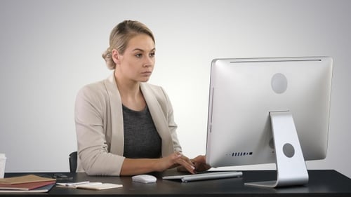 Classy happy businesswoman working at computer on gradient