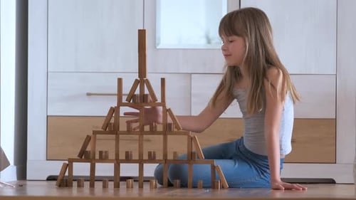 Creative Child Girl Playing with Game Stacking Wooden Toy Blocks in High Building Structure