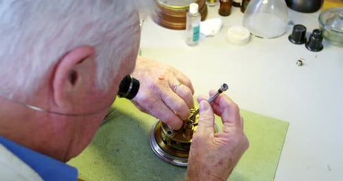 Clockmaker Repairing Intricate Mechanical Clock with Magnifier