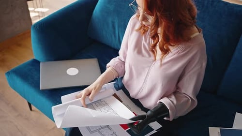 Progressive Girl Interior Designerin arbeitet beim Sitzen auf dem Home-Office-Sofa