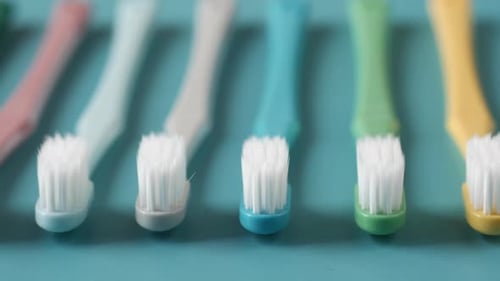 Colorful Toothbrushes on Light Green Background
