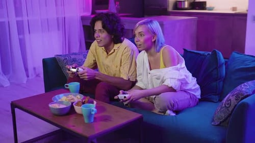 Young Couple Playing Video Games at Home at Night